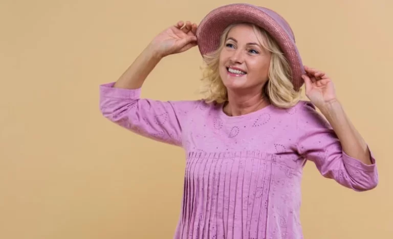 Mujer senior rubia que llevaba un sombrero rosa